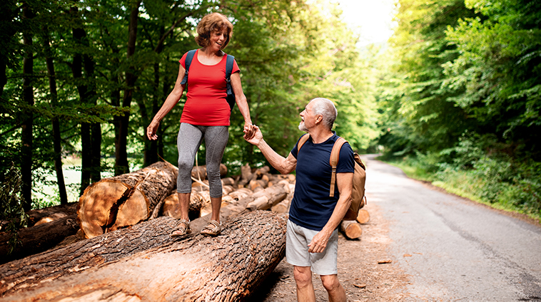 senior-tourist-couple-with-backpacks-walking-in-fo-lt9v8na