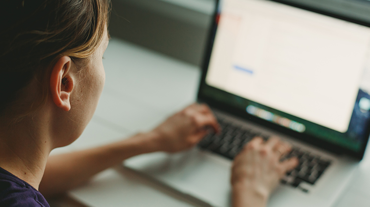 woman-working-with-laptop-placed-on-wooden-desk-p4az79g