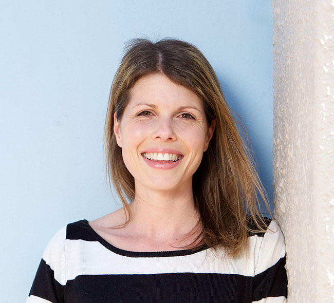 smiling woman leaning against wall 